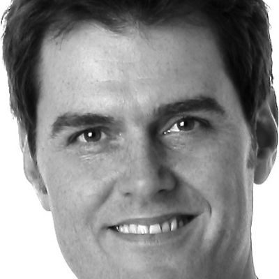 A close-up of a man with short dark hair, smiling.