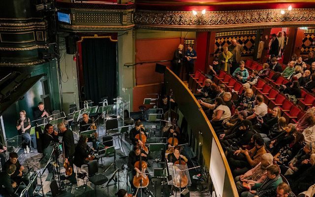 The Orchestra of Opera North performing in the pit to an audience at Leeds Grand Theatre.