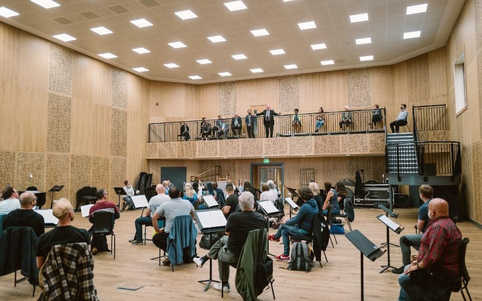 A picture of inside the Mantle Music Studio, a very large room with acoustic panels and a large wood floor.