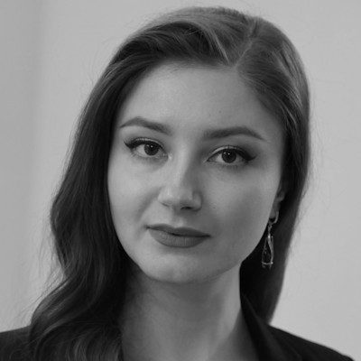 A black and white portrait of a woman with long dark hair looking at the camera.