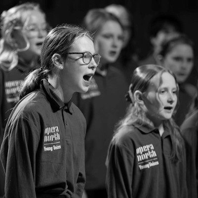 A black and white image of the Opera North Young Voices children singing.