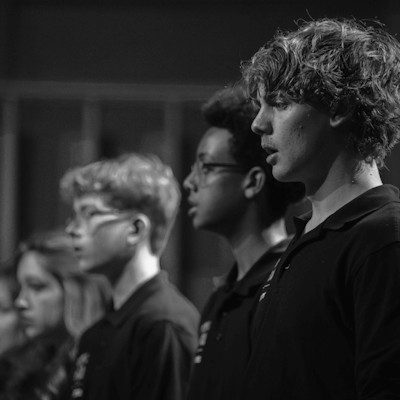 A black and white image of the Opera North Youth Chorus singing.