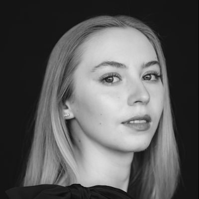 A close-up black and white portrait of a woman with long blonde hair.