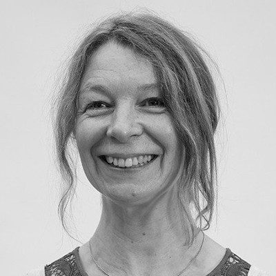 A woman with long hair, smiling at the camera
