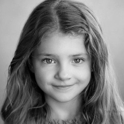 A black and white close-up of a girl with long dark hair.