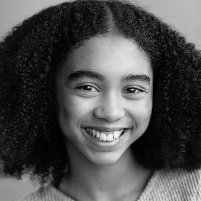 A black and white close-up of a girl with long dark hair wearing a light top.