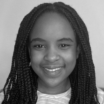 A black and white close-up of a girl with long box braids, wearing a light top.