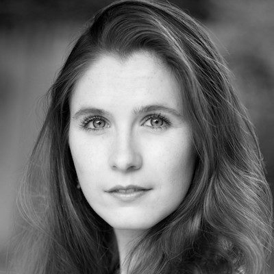 A black and white close-up of a woman with long dark hair.