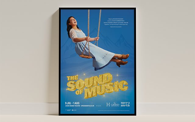 A framed poster showing Maria from The Sound of Music on a swing laughing, with the caption 