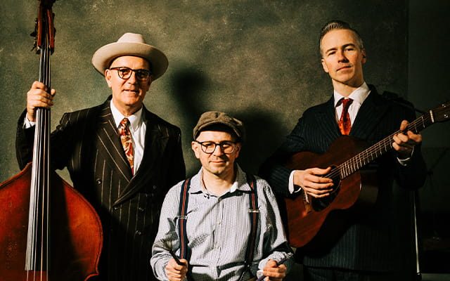 The Meanwood Valley Stompers - a swing band in retro American attire, posing with a bass and acoustic guitar.