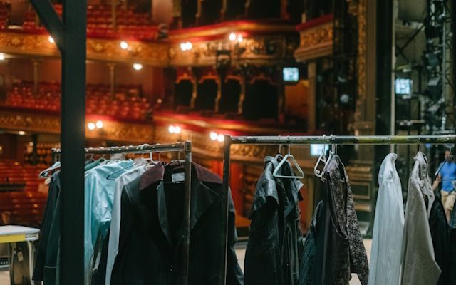 Garments hanging on a clothes rack inside Leeds Grand theatre.