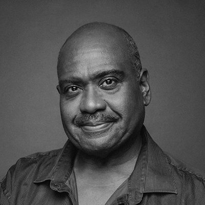 A black man with bold hair and a moustache